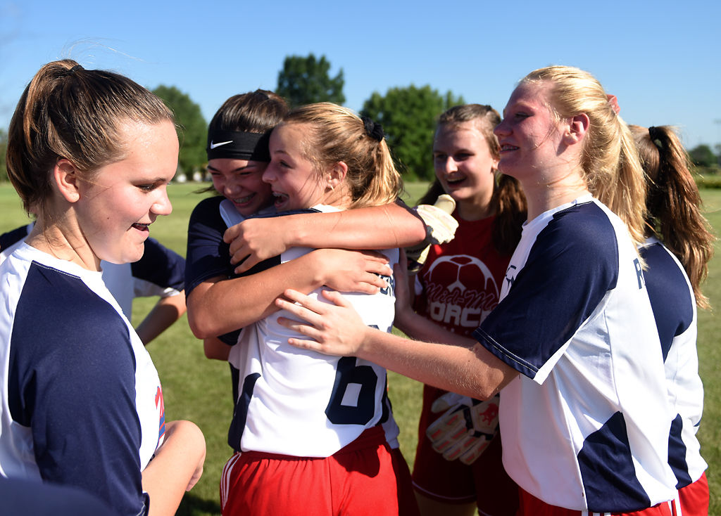 Landry Watson, 14, is congratulated by her teammates after scoring a goal